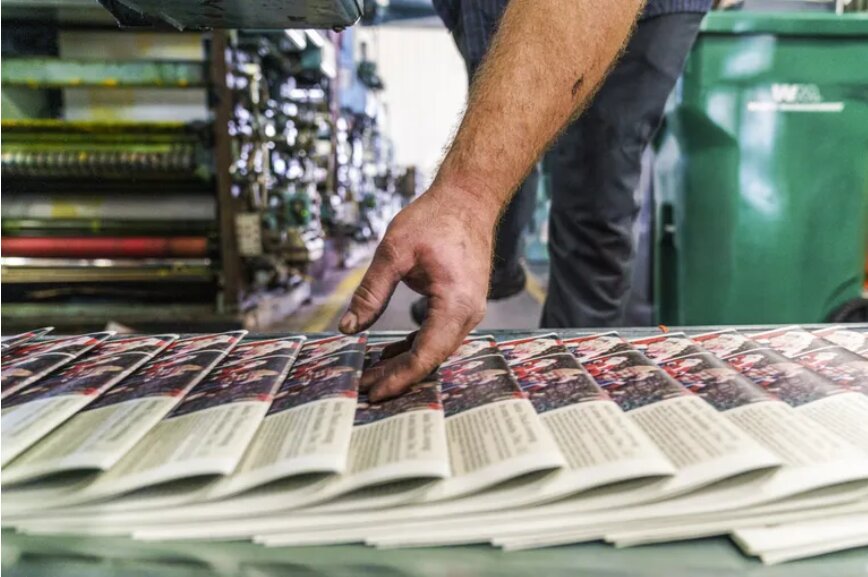 “I don’t believe Seattle should proceed with a proposal that’s gestating to create news vouchers, modeled on the city’s $30 million democracy voucher program,” writes Free Press editor Brier Dudley. Pictured are newspapers fresh off a printing press conveyor belt in Minnesota. (David Goldman / AP, 2021)